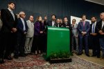 Um grupo de políticos está reunido em uma coletiva de imprensa. No centro, um homem está falando ao microfone, enquanto os outros estão ao seu redor, ouvindo atentamente. O fundo é uma parede escura e há um painel verde à frente, com uma pequena planta na base. Os políticos estão vestidos formalmente, com ternos e gravatas, e a atmosfera parece ser de seriedade e atenção. Entrevista de representantes da Frente Nacional de Prefeitos, em julho de 2023, sobre a reforma tributária, no Salão Nobre do Congresso Nacional. Na imagem, o prefeito de São Paulo, Ricardo Nunes, ao lado do prefeito Eduardo Paes (Rio de Janeiro), atual presidente da FNP.